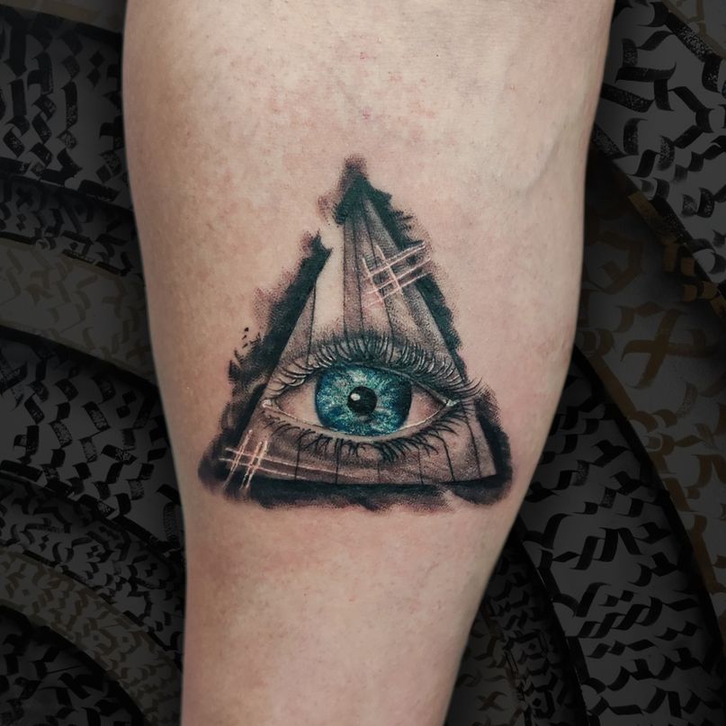 tatuaje ojo illuminati realista en triangulo eye blue