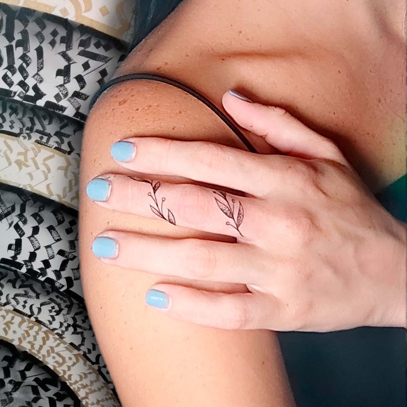 tatuaje floral en el dedo de mujer 